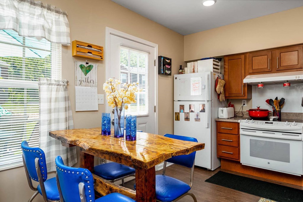 a kitchen with a wooden table and blue chairs