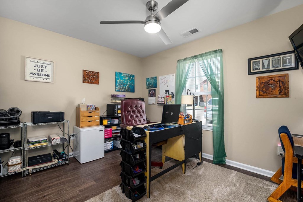 a bedroom with a desk and a window
