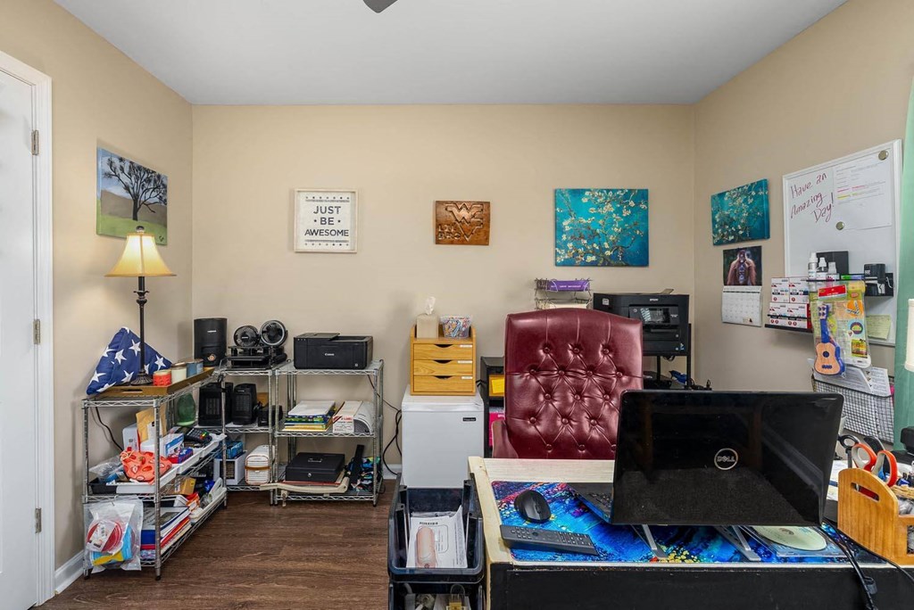 a room with a computer desk and a red chair