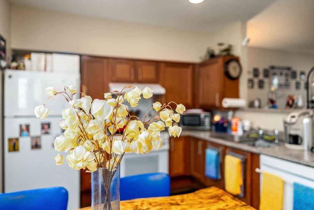 a vase of flowers on a table in a kitchen