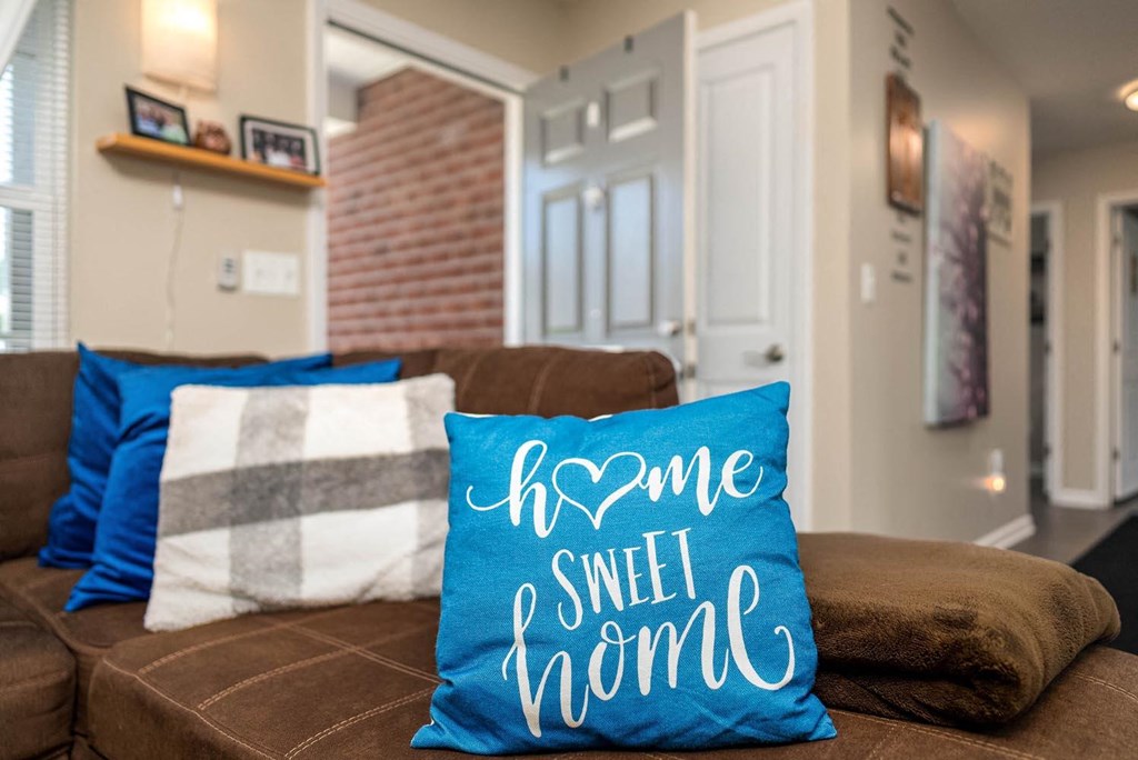 a couch with a pillow that says home sweet home