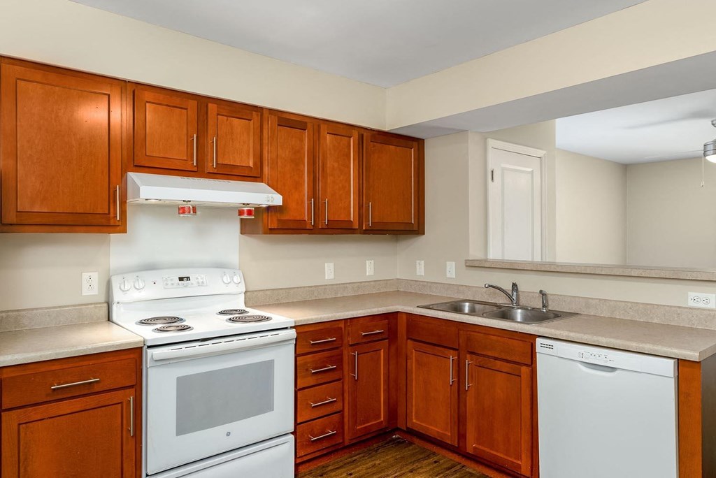 a kitchen with wood cabinets and white appliances