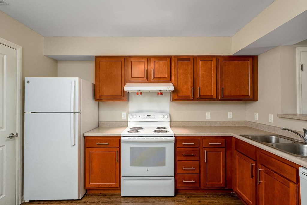 a kitchen with wooden cabinets and white appliances