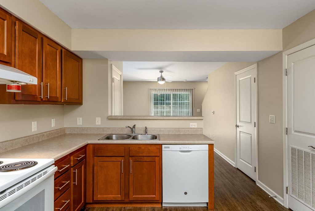 a kitchen with wooden cabinets and a white dishwasher