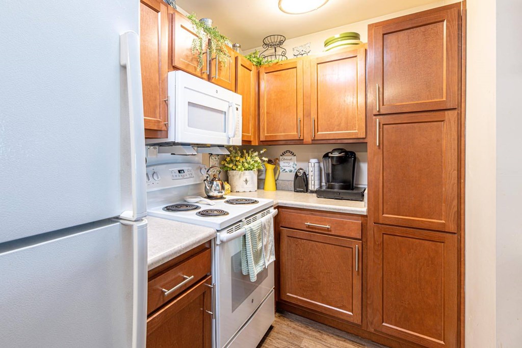 A kitchen with wooden cabinets and a white refrigerator.