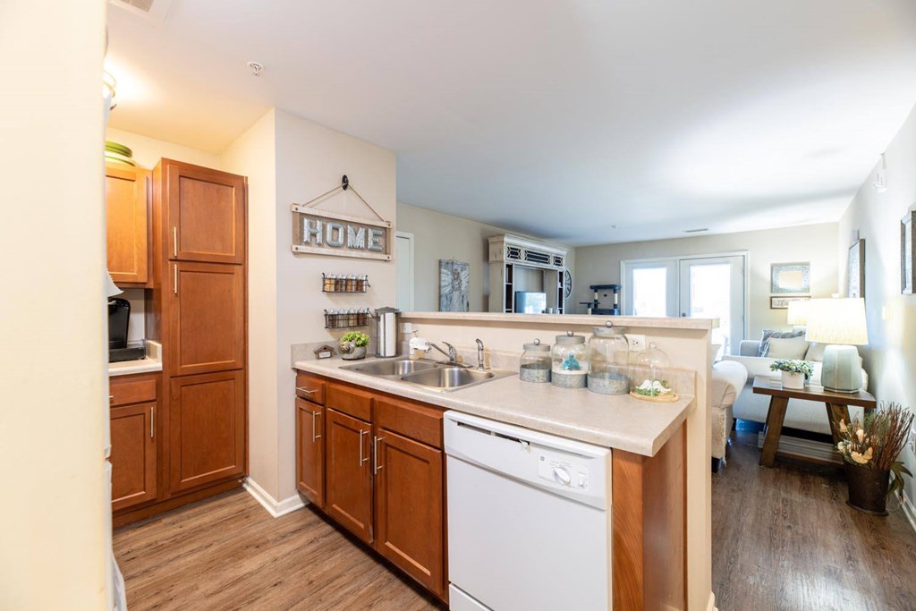 A kitchen with wooden cabinets and a white dishwasher.