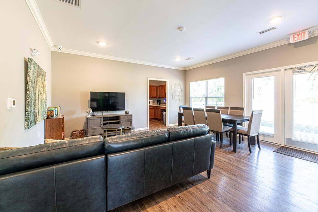 A living room with a black couch and a television.