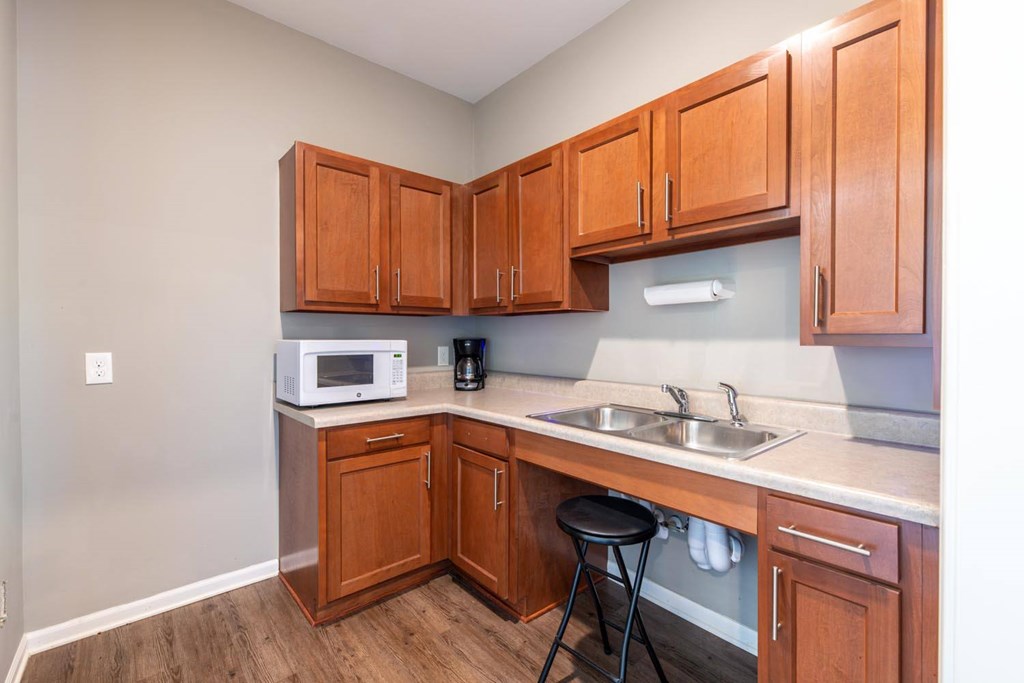 A kitchen with wooden cabinets and a white microwave.