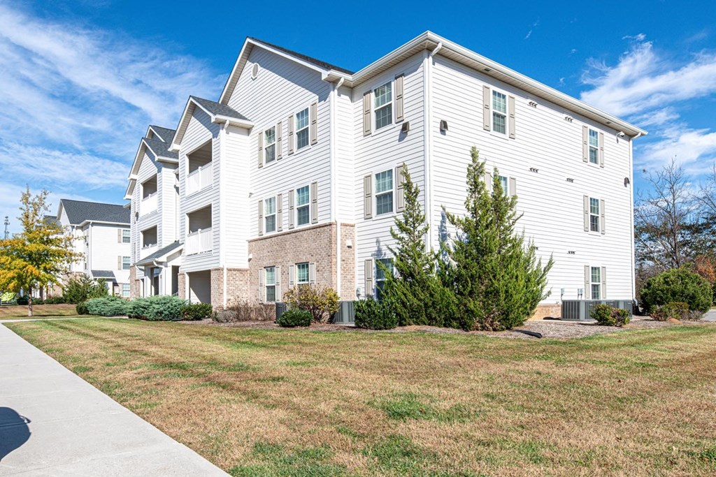 A white apartment building with a clear blue sky above it.