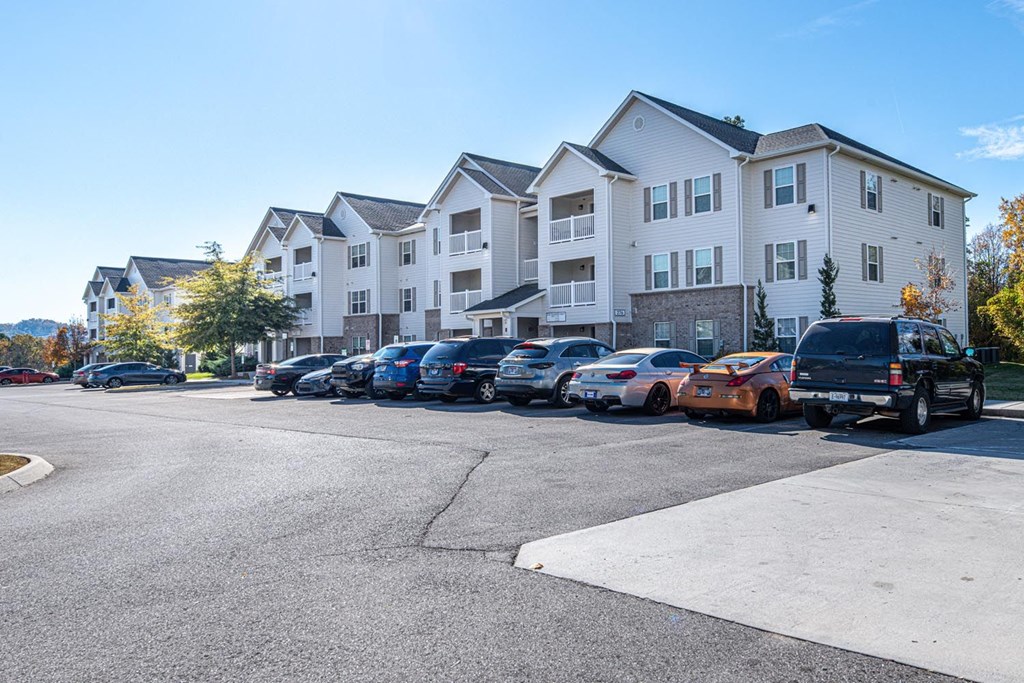 A parking lot with cars and apartment buildings in the background.