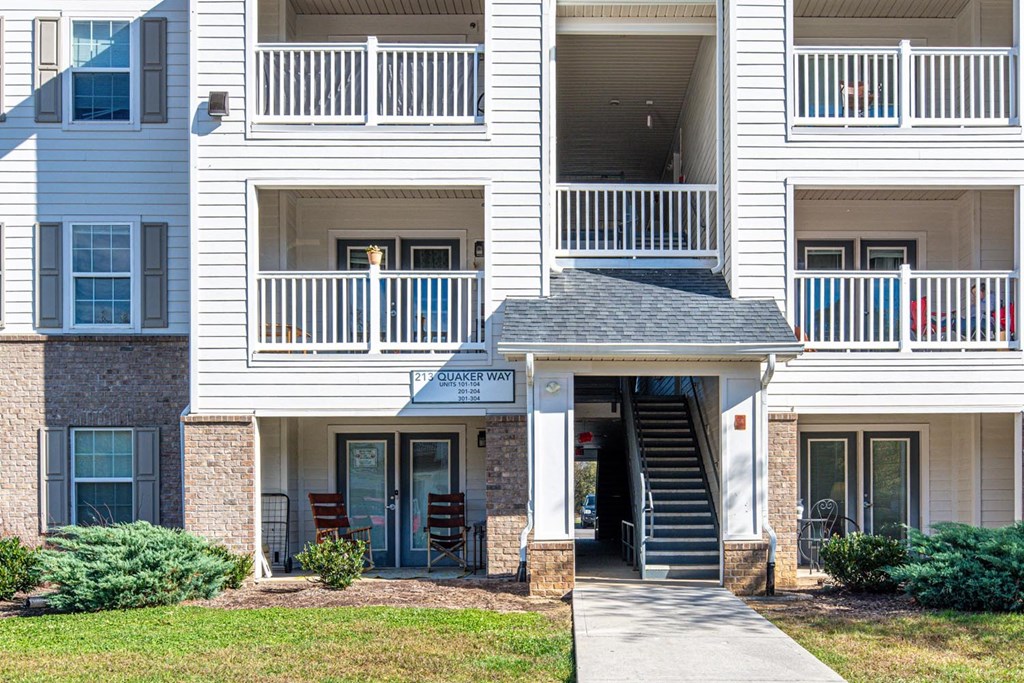 A white apartment building with a black roof and a sign that says "Squaker Way".