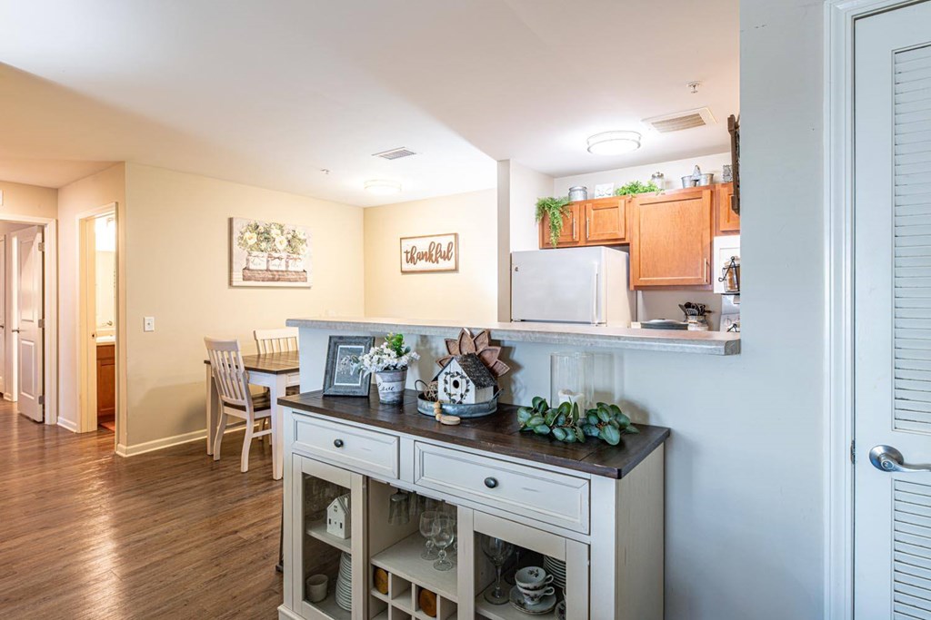 A kitchen with a white refrigerator and wooden cabinets.