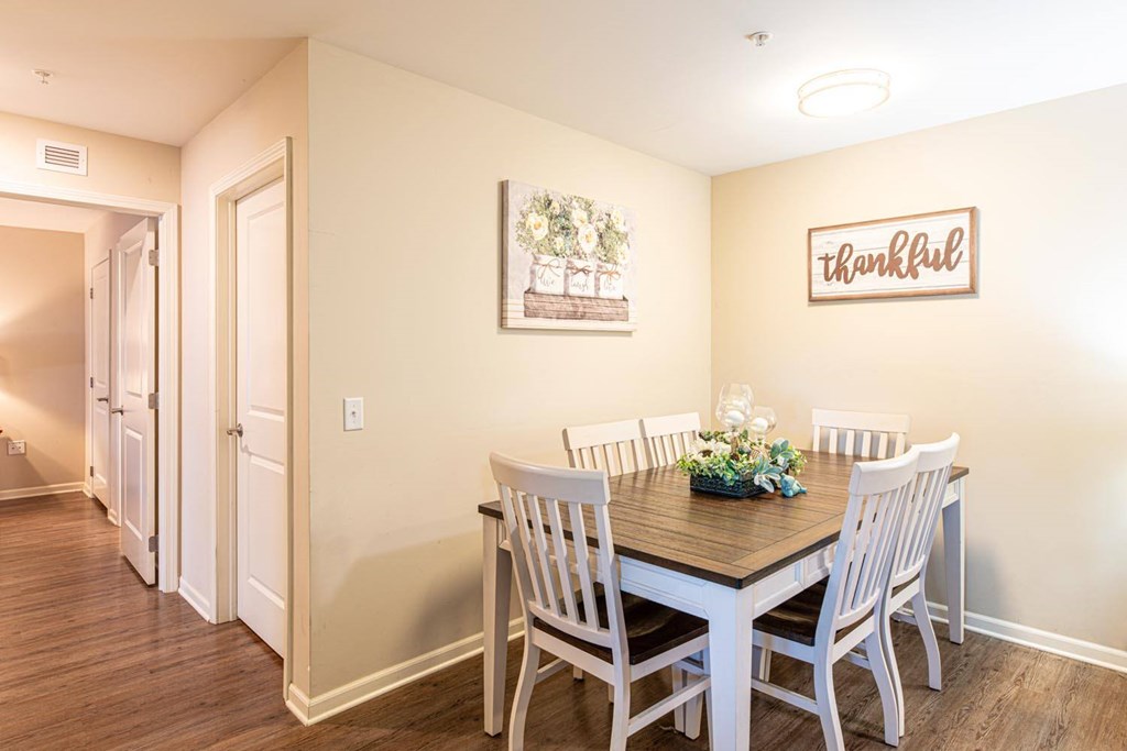 A dining room with a wooden table and chairs.