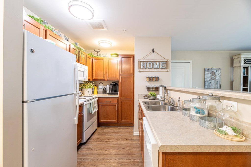 A kitchen with a white refrigerator and wooden cabinets.