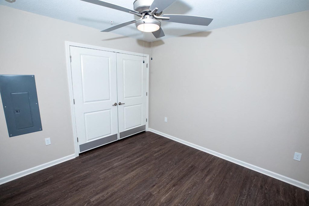 a bedroom with a ceiling fan and a closet