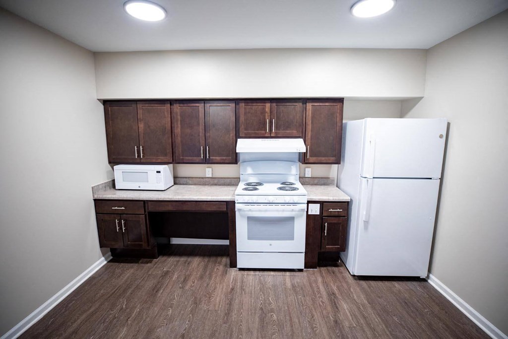 a small kitchen with a stove refrigerator and cabinets