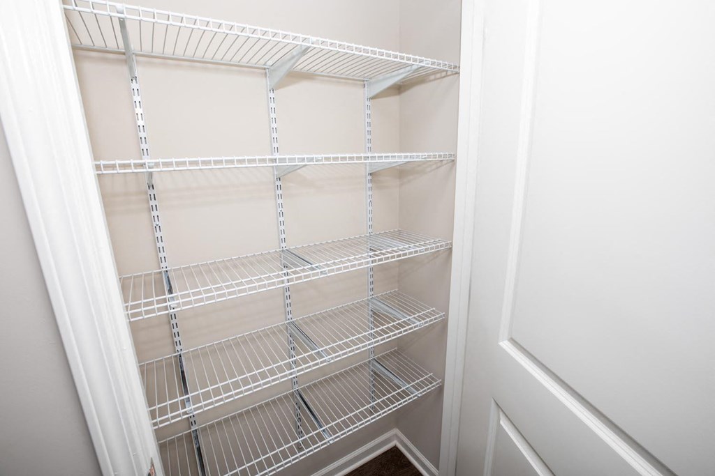 a closet with white wire shelves and a white door