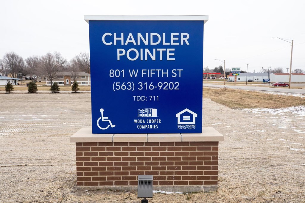 a sign for a chandler pointe parking lot with a handicap sign
