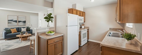 A kitchen with a white refrigerator and wooden cabinets.