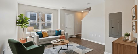 A living room with a green chair and a couch with pillows.