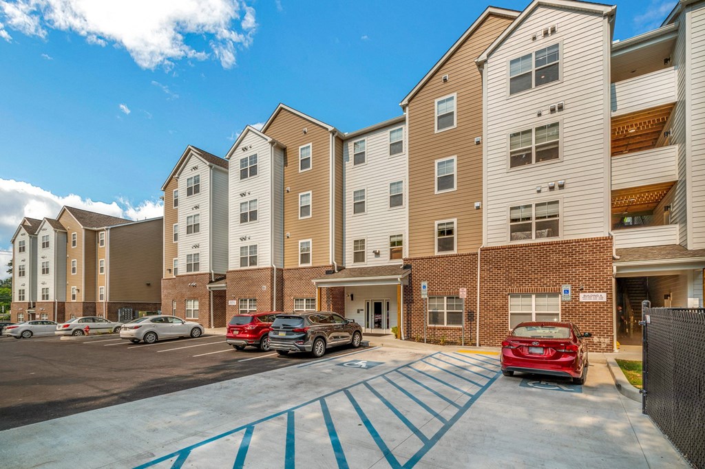a parking lot with cars in front of an apartment building