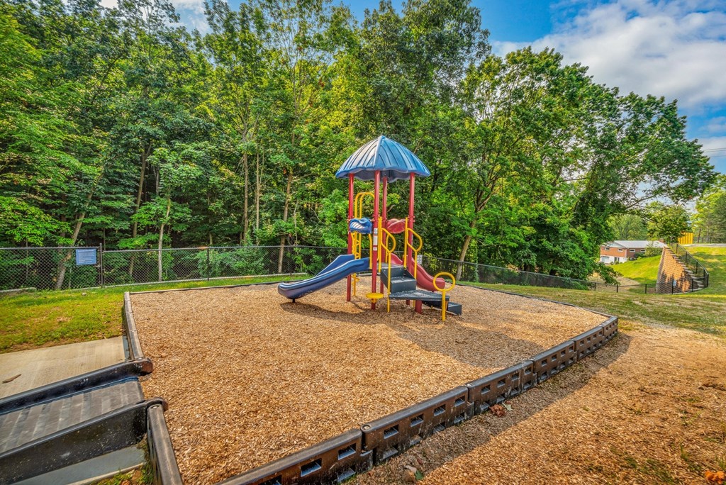 a playground with a swing set and slides in a park
