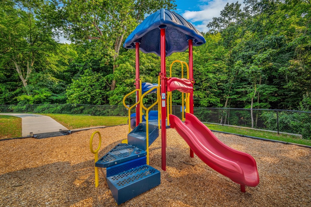 a playground with a swing set and slides at a park