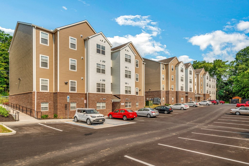 a parking lot with cars in front of an apartment building