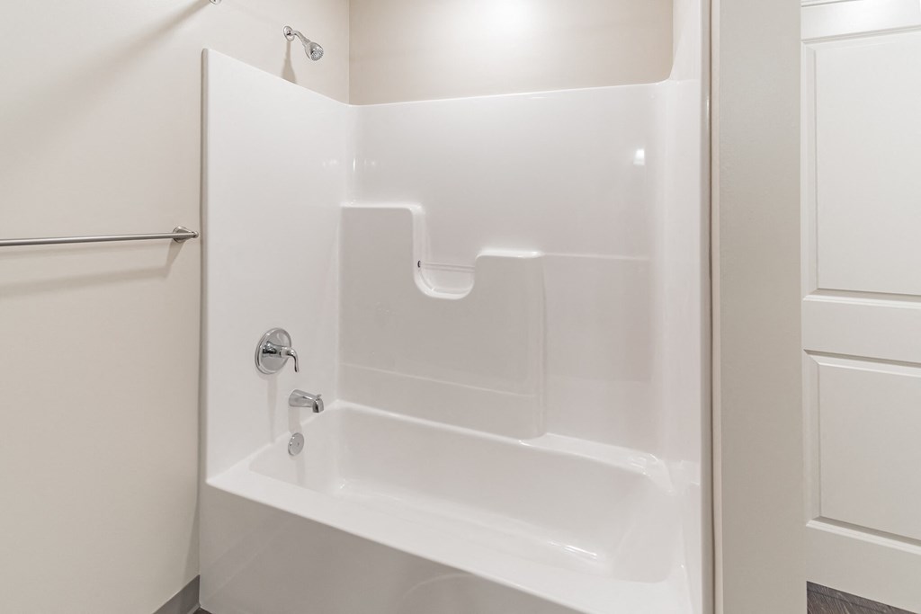 a small bathroom with a white tub and a shower