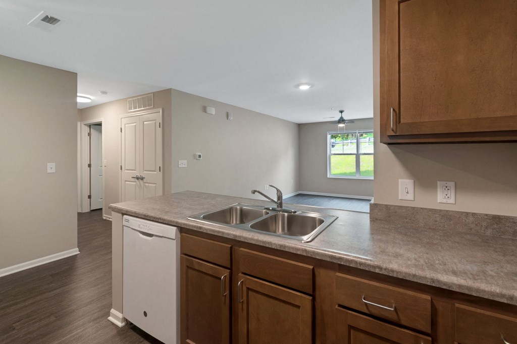 an empty kitchen with a sink and wooden cabinets