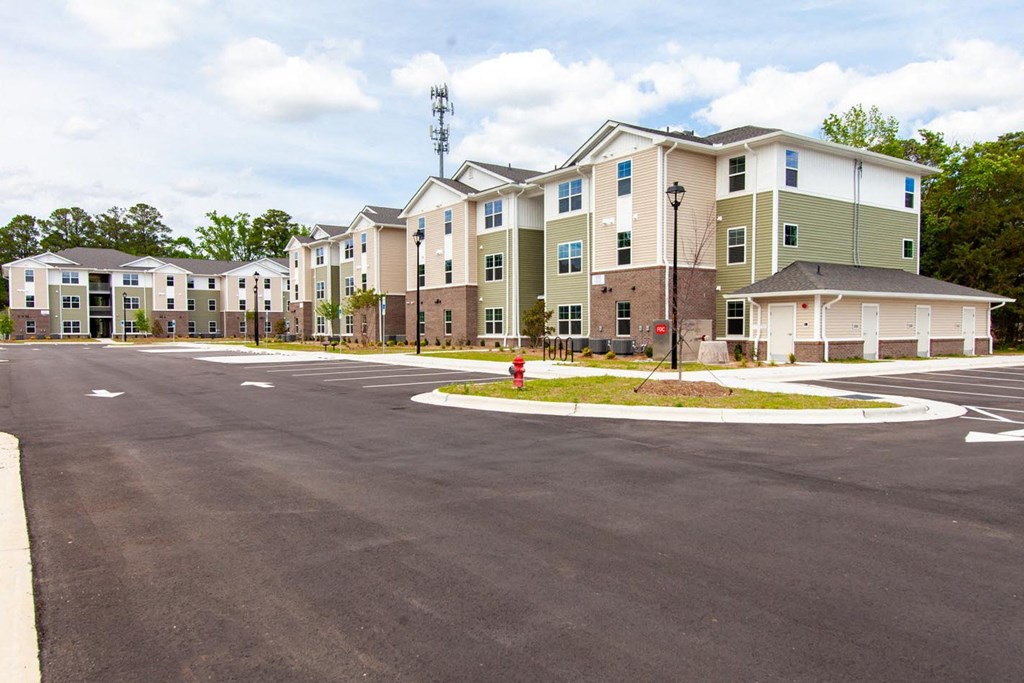 an empty parking lot in front of an apartment building