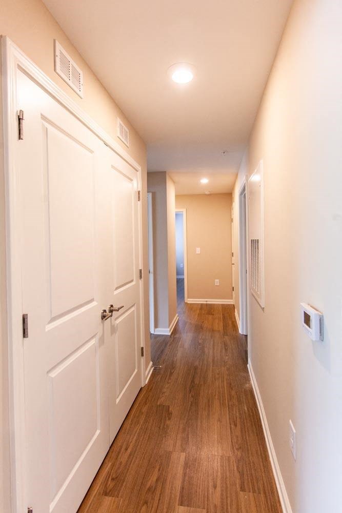 a hallway with white doors and a wood floor