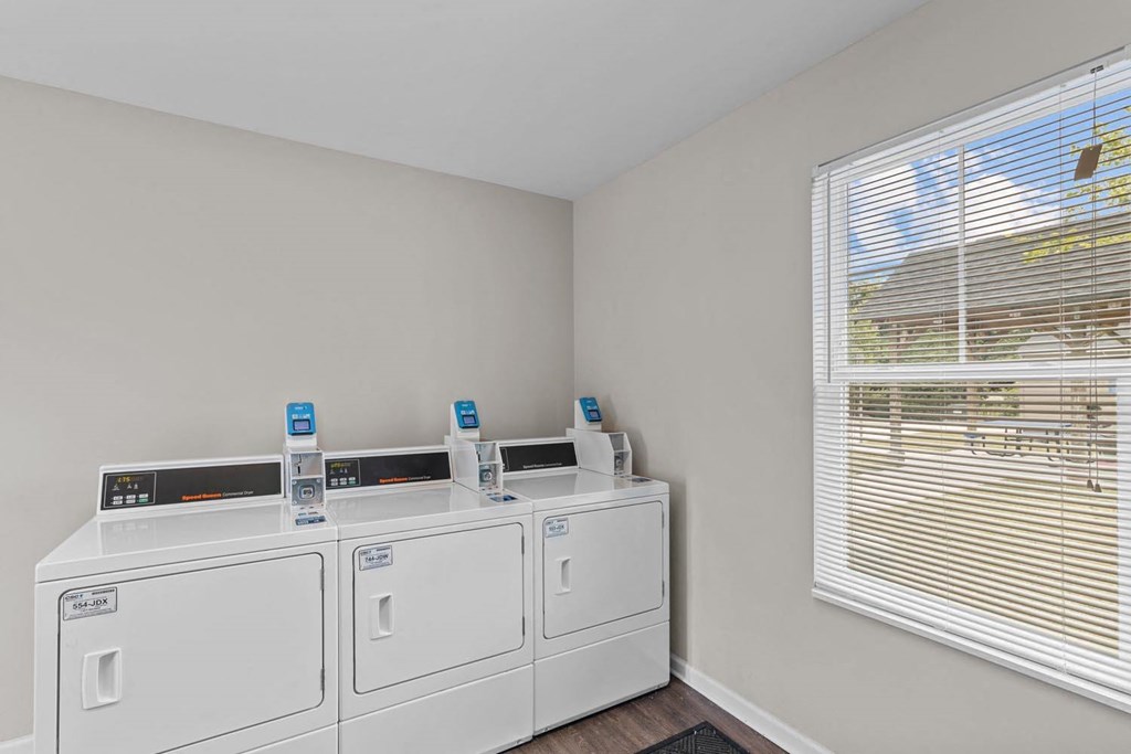 a laundry room with two washes and a window with blinds