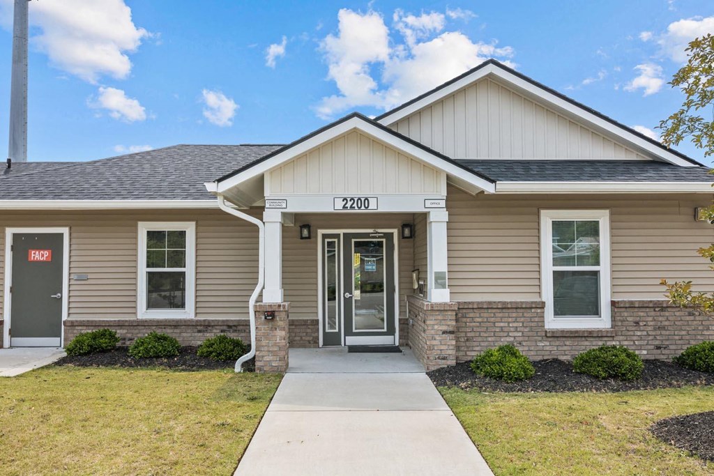 the exterior of a tan house with a sidewalk in front of it