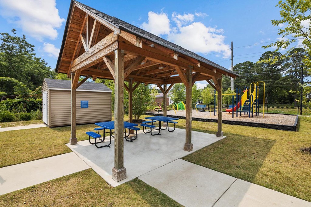 a picnic pavilion with picnic tables and a playground