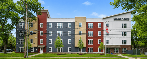 A large apartment complex with multiple buildings and a flag on the front.