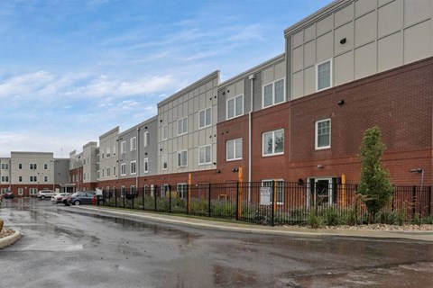 an empty parking lot in front of an apartment building