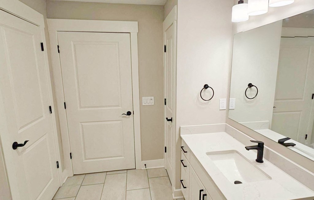 a bathroom with a sink and a mirror and a door