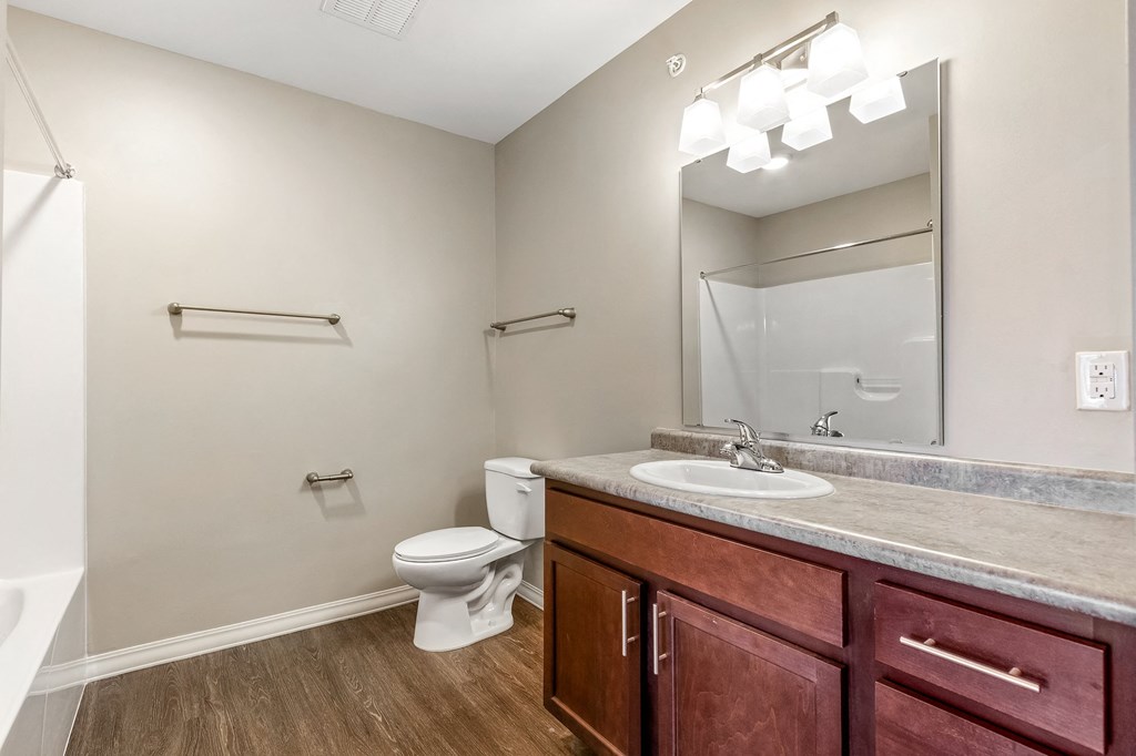 an empty bathroom with a sink toilet and mirror