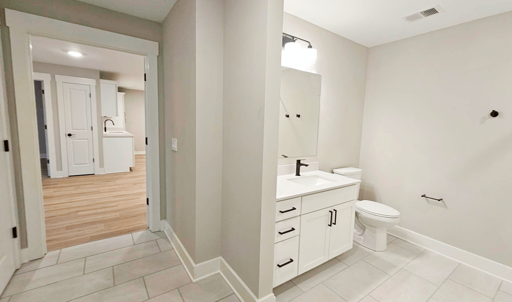 a white bathroom with a toilet and a sink
