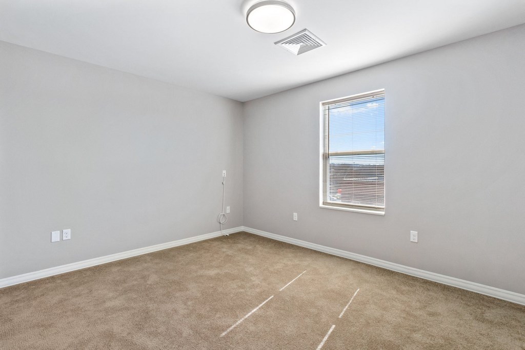an empty room with carpet and a window