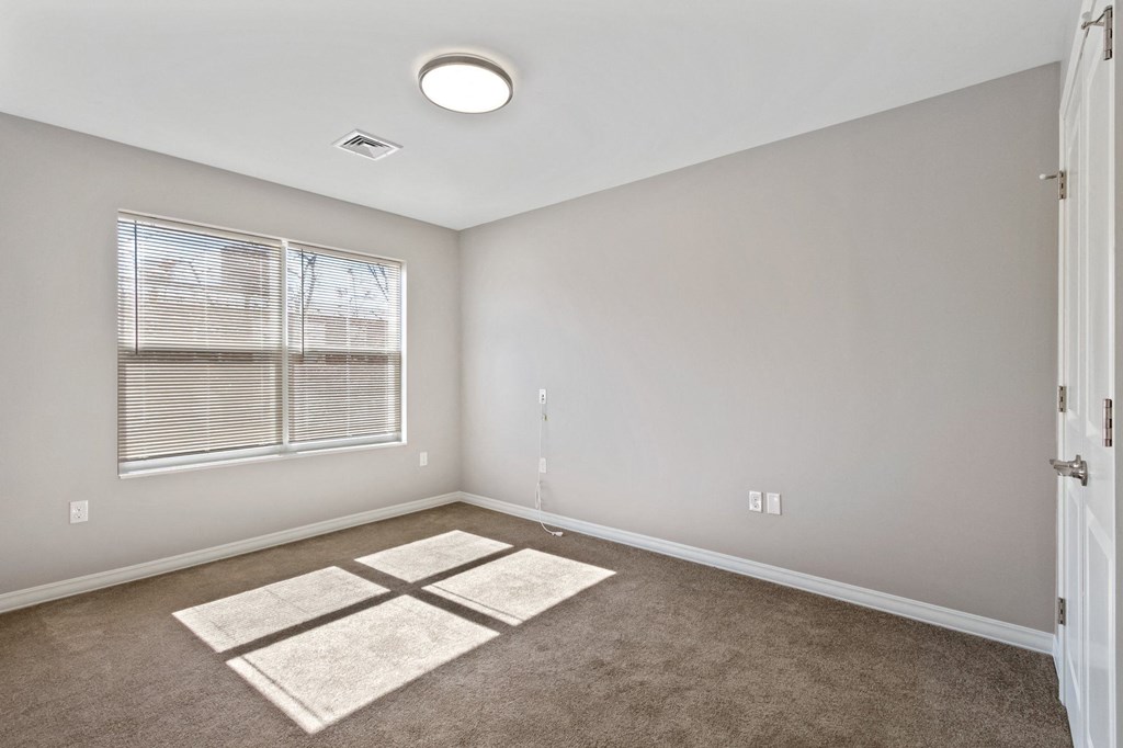 an empty room with carpet and a window