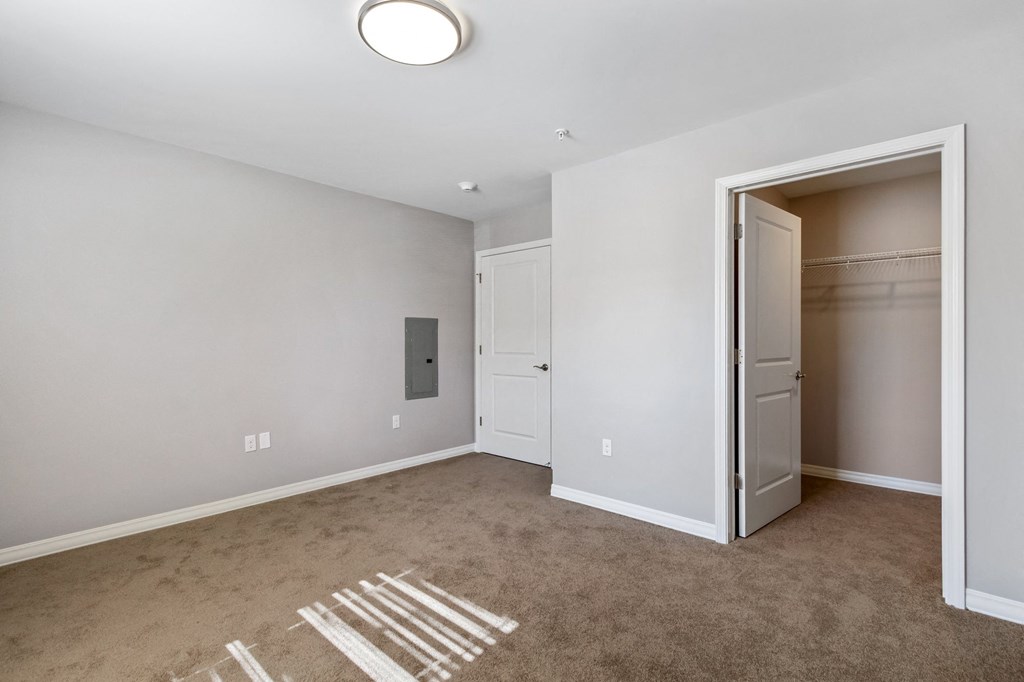 an empty room with a closet and an open door