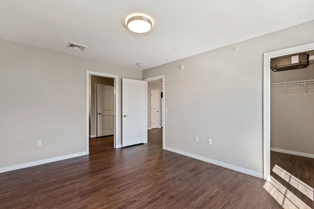 an empty living room with wood flooring and a closet