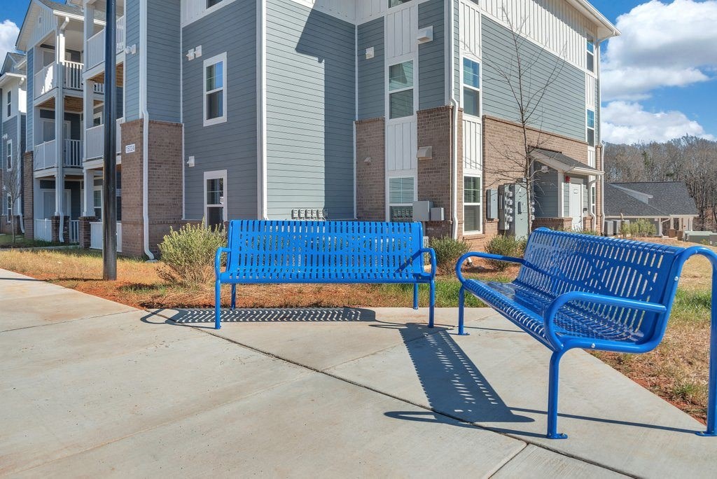two blue benches in front of apartment buildings