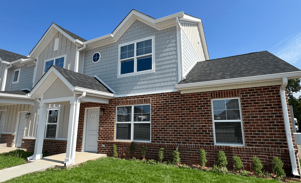 a house with a blue roof and a brick exterior