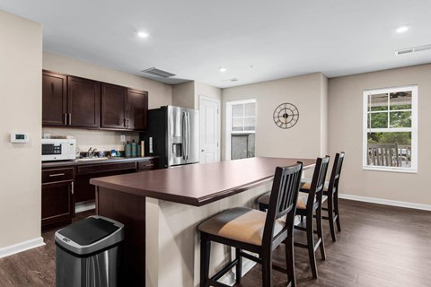 a kitchen with a counter and chairs