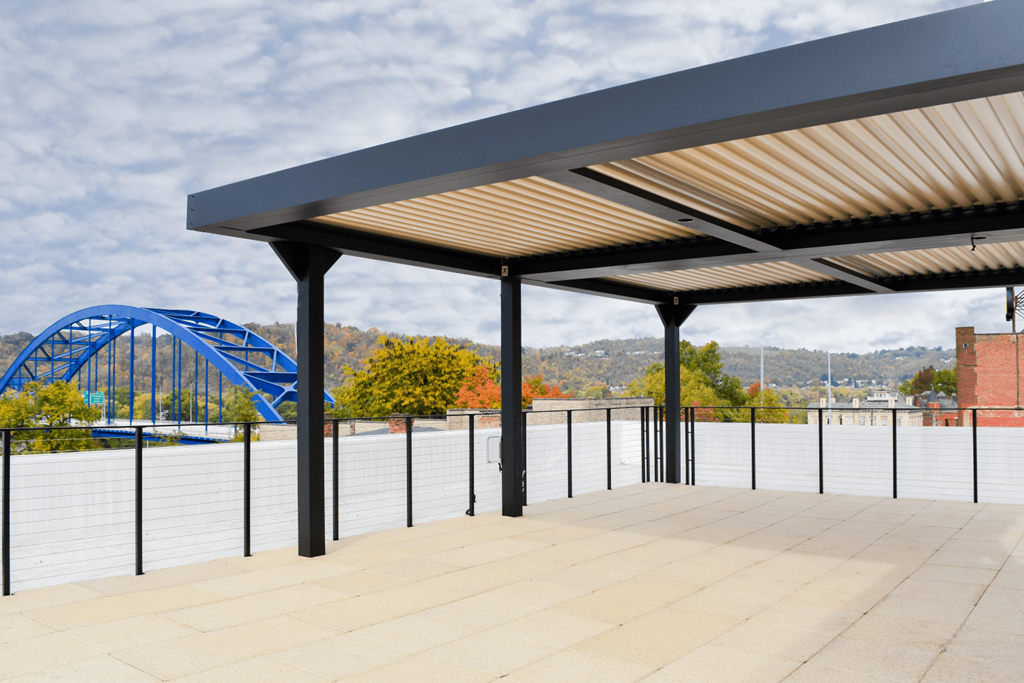 awnings on a roof overlooking a river with a roller coaster in the background