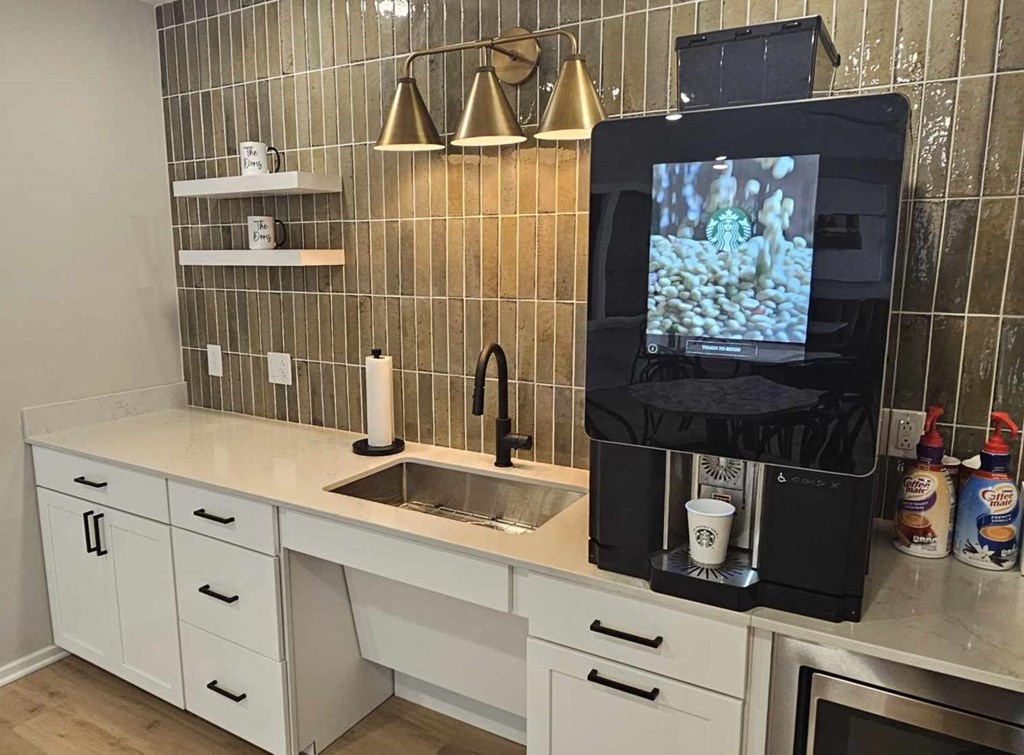 a kitchen with a sink and a coffee maker on the counter
