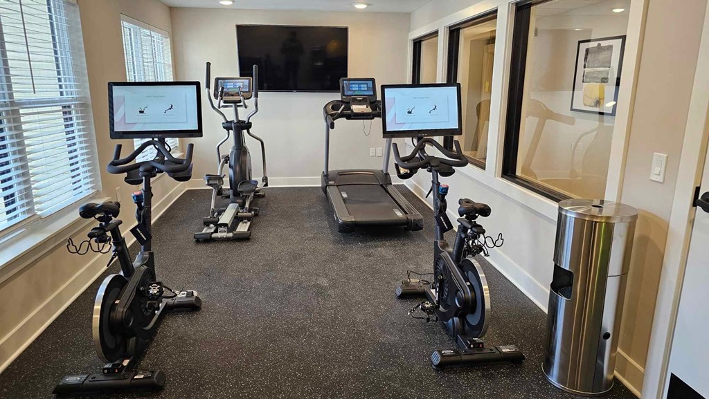 a gym with exercise equipment in a room with windows
